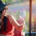 Woman appreciating the color of her glass of Coursey Graves wine through the sunlight