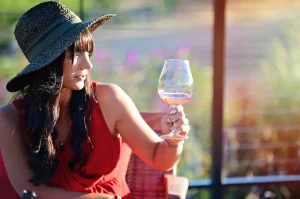 Woman appreciating the color of her glass of Coursey Graves wine through the sunlight