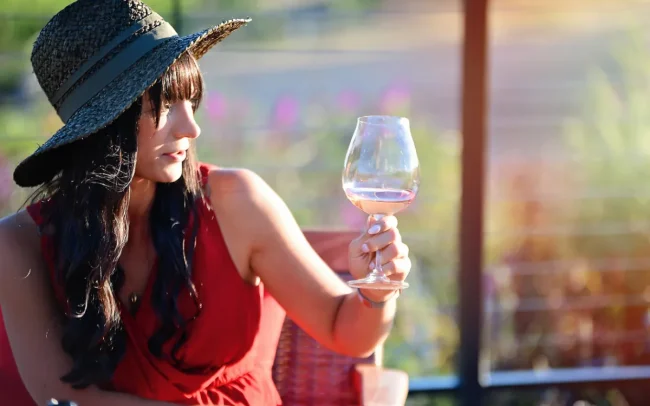 Woman appreciating the color of her glass of Coursey Graves wine through the sunlight