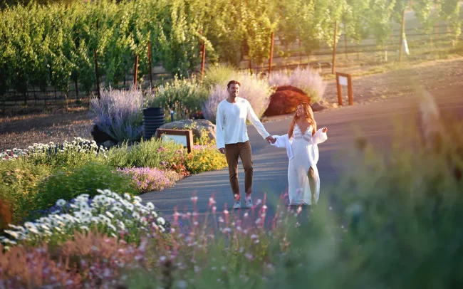 A couple strolling through the Coursey Graves vineyards, gardens, and property