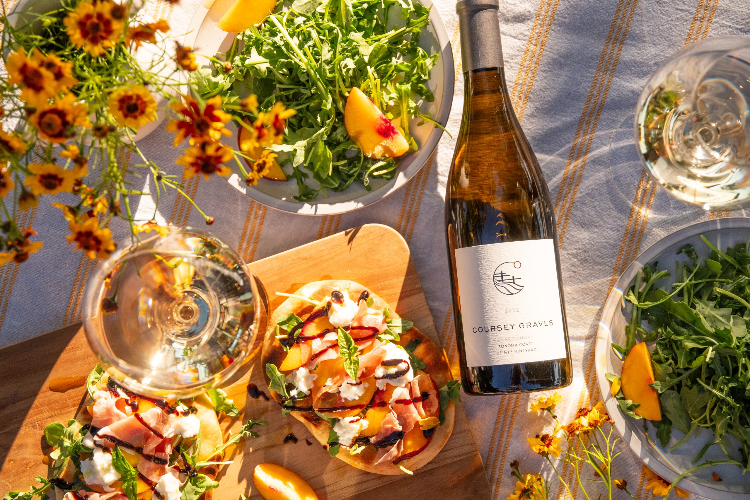 Bottle of Coursey Graves wine on a summertime outdoor table with food
